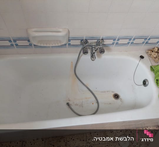 אמבטיה עם ברז, צינור ומגבות בצד